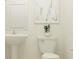 Clean bathroom with pedestal sink, modern toilet, and minimalist wall decor at 13035 Ruby Gold Ct, Wimauma, FL 33598