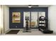 Well-equipped exercise room with a treadmill, stationary bike, and mirrors, set against a stylish dark blue accent wall at 13035 Ruby Gold Ct, Wimauma, FL 33598