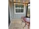 Screened porch featuring tile flooring and a small seating area at 152 Chelsea Ct, Dunedin, FL 34698