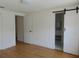 Bright bedroom with a barn door leading to the bathroom and wood-look flooring throughout at 16147 Sagebrush Rd, Tampa, FL 33618