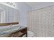 Bathroom with a modern vanity with glass bowl sink and patterned shower curtain over the tub at 17106 Carrington Park Dr # 622, Tampa, FL 33647