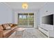 Bright living room featuring a sliding door to the balcony, modern furnishings, and light-colored tile flooring at 17106 Carrington Park Dr # 622, Tampa, FL 33647
