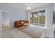 Bright living room featuring a sliding door to the balcony, modern furnishings, light-colored tile flooring, and ample lighting at 17106 Carrington Park Dr # 622, Tampa, FL 33647