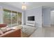 Bright living room featuring a sliding door to the balcony, modern furnishings, and light-colored tile flooring at 17106 Carrington Park Dr # 622, Tampa, FL 33647