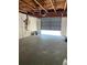 Garage with exposed ceiling beams, concrete floor, and open door to the outside at 2016 Essex Dr, Holiday, FL 34691