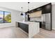 Modern kitchen featuring a large island with marble countertop, stainless steel refrigerator, and light wood floors at 211 W Columbus Dr # 1, Tampa, FL 33602