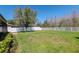 Spacious backyard with green grass, mature tree, and white privacy fence, perfect for outdoor activities at 2208 Landside Dr, Valrico, FL 33594