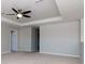 Bedroom with neutral carpet, tray ceiling, and ensuite bathroom access at 2208 Landside Dr, Valrico, FL 33594