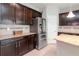 Kitchen featuring stainless steel refrigerator and dark wood cabinets and granite counters at 2208 Landside Dr, Valrico, FL 33594