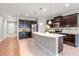 Stylish kitchen with stainless steel appliances, dark wood cabinets, and a large island with granite countertops at 2208 Landside Dr, Valrico, FL 33594