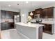 Modern kitchen features a center island, stainless steel appliances, dark wood cabinets, and granite countertops at 2208 Landside Dr, Valrico, FL 33594