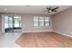 Living room with wood floors, ceiling fan, and sliding glass doors to screened patio at 2208 Landside Dr, Valrico, FL 33594