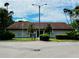 Exterior shot of clubhouse features a front lawn, palm trees, and flag at 2213 65Th N Ave # 2213, St Petersburg, FL 33702