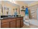 Bathroom featuring dark cabinets, a tiled shower/tub combo, and tropical decor at 2240 Parrot Fish Dr, Holiday, FL 34691