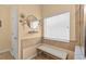 Cozy bathroom nook featuring a small bench, decorative mirror, and tiled walls at 2240 Parrot Fish Dr, Holiday, FL 34691