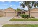 Charming single-story home featuring a well-manicured lawn, mature palm trees, and an attached two-car garage at 2240 Parrot Fish Dr, Holiday, FL 34691