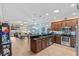 Open-concept kitchen featuring stainless steel appliances, dark wood cabinetry, and a view of the living area at 2240 Parrot Fish Dr, Holiday, FL 34691