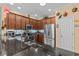 Modern kitchen with stainless steel appliances, dark wood cabinets, granite countertops, and mosaic backsplash at 2240 Parrot Fish Dr, Holiday, FL 34691
