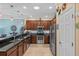 Modern kitchen featuring stainless steel appliances, dark wood cabinets, granite countertops, and mosaic backsplash at 2240 Parrot Fish Dr, Holiday, FL 34691