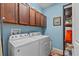 Laundry room featuring Whirlpool washer and dryer with overhead cabinets at 2240 Parrot Fish Dr, Holiday, FL 34691