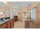 Luxurious main bathroom featuring double vanity sinks, a soaking tub, and a glass-enclosed shower at 2240 Parrot Fish Dr, Holiday, FL 34691