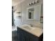Bathroom featuring a tub, a toilet and a grey vanity with a light countertop and decorative mirror at 2484 Roberta St, Largo, FL 33771