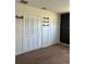 Bedroom featuring beige carpet, a white wall and three closets with white louvered doors at 2484 Roberta St, Largo, FL 33771
