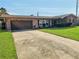 A cozy brick house with a well-maintained front lawn and a driveway leading to an attached garage at 2484 Roberta St, Largo, FL 33771