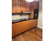 Features wood-look floors, wood cabinets, and black countertop at 2484 Roberta St, Largo, FL 33771