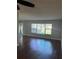A bright living room with hardwood floors, a large window with blinds, and a partial view of the entry door at 2484 Roberta St, Largo, FL 33771