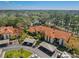 Aerial view of a property with covered parking and red tiled roofs in a green, tree-filled neighborhood at 2632 Enterprise E Rd # A23, Clearwater, FL 33759