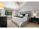 The main bedroom features a gray tufted headboard and a sliding glass door to the lanai at 2632 Enterprise E Rd # A23, Clearwater, FL 33759
