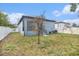 A home showcasing the fenced in backyard with landscaping and a covered porch at 3405 Phillips St, Tampa, FL 33619