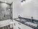 Modern bathroom featuring a double sink vanity with granite countertop and a bathtub and frameless glass shower at 3405 Phillips St, Tampa, FL 33619