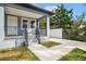 Charming home showcasing a covered front porch with black railings and fresh landscaping at 3405 Phillips St, Tampa, FL 33619