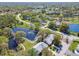 Picturesque aerial view of a neighborhood with a beautiful pond and lush green surroundings at 3462 Sutton Pl, Palm Harbor, FL 34684