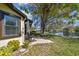 The backyard patio has mature landscaping and overlooks the lake at 3462 Sutton Pl, Palm Harbor, FL 34684