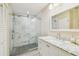 Modern bathroom featuring a glass-enclosed shower with marble tiles and a white vanity with a marble countertop at 3462 Sutton Pl, Palm Harbor, FL 34684