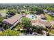 Aerial view of a spacious clubhouse with a pool, well-manicured landscaping, and ample parking at 3462 Sutton Pl, Palm Harbor, FL 34684