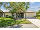 Exterior view of a charming single-story home featuring mature trees and a cozy, screened front porch at 3462 Sutton Pl, Palm Harbor, FL 34684