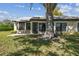 The backyard features mature trees and landscaping with a patio at 3462 Sutton Pl, Palm Harbor, FL 34684