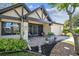 Charming home exterior showcasing a cozy front porch with beautiful landscaping and an attached one car garage at 3462 Sutton Pl, Palm Harbor, FL 34684