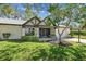 Charming home exterior with a well-maintained lawn, screened porch, and attached garage at 3462 Sutton Pl, Palm Harbor, FL 34684