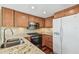 Kitchen with wood cabinets, stainless steel appliances, and granite countertops at 3462 Sutton Pl, Palm Harbor, FL 34684