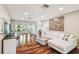 Bright living room featuring hardwood floors, white couch, and sliding glass doors to outside at 3462 Sutton Pl, Palm Harbor, FL 34684