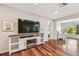 Cozy living room featuring an electric fireplace, and large windows offering views of the community pond at 3462 Sutton Pl, Palm Harbor, FL 34684
