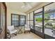 Cozy screened porch featuring tile floors and comfortable seating with views of the landscaped front yard at 3462 Sutton Pl, Palm Harbor, FL 34684