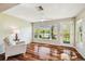 Cozy sun room with hardwood floors, ceiling fan, and large windows overlooking the water at 3462 Sutton Pl, Palm Harbor, FL 34684