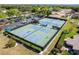 An inviting aerial view of well-maintained tennis courts, ideal for recreation and community engagement at 3462 Sutton Pl, Palm Harbor, FL 34684