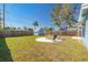 Expansive backyard with green grass, a wooden fence, a shed, and a sand firepit provides ample space for outdoor enjoyment at 358 51St N Ave, St Petersburg, FL 33703